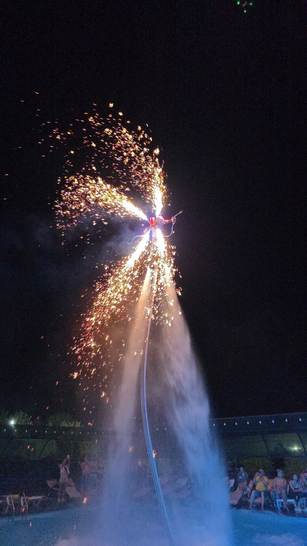 Flyboard fire and spark show high above a night pool in Phuket